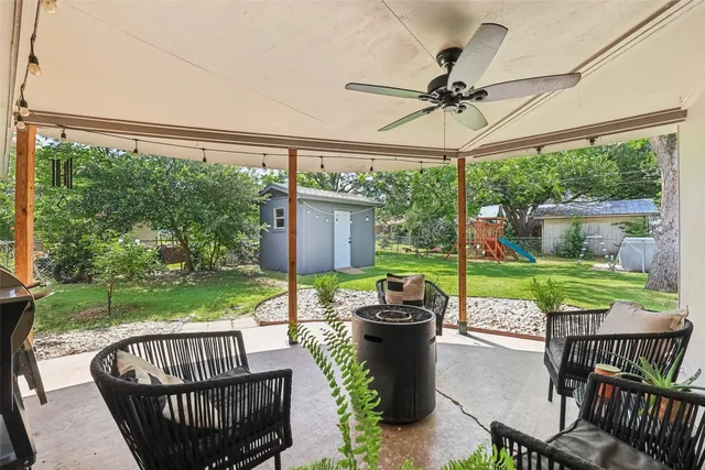 a view of a patio with a table chairs and a yard