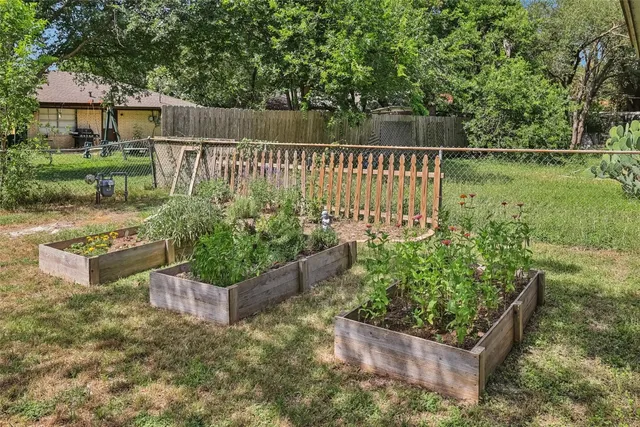 a view of a garden with wooden fence