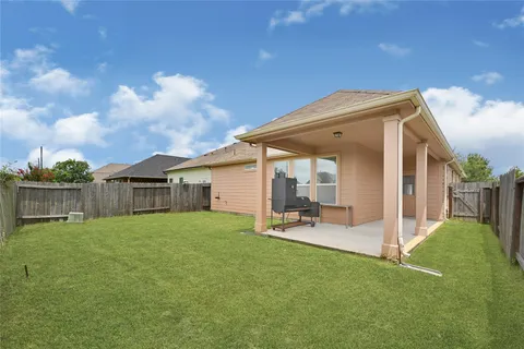 a view of a chair and table in backyard of the house