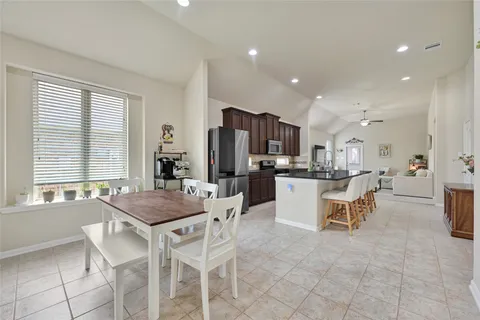 a kitchen with kitchen island a dining table and chairs