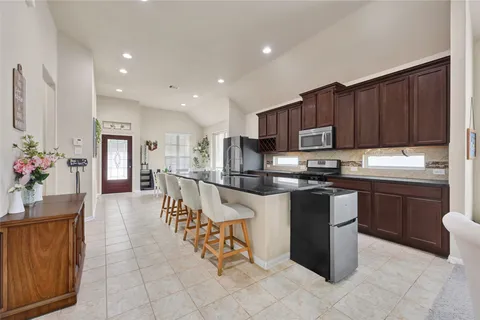 a kitchen with stainless steel appliances granite countertop a stove top oven a sink dishwasher and a refrigerator