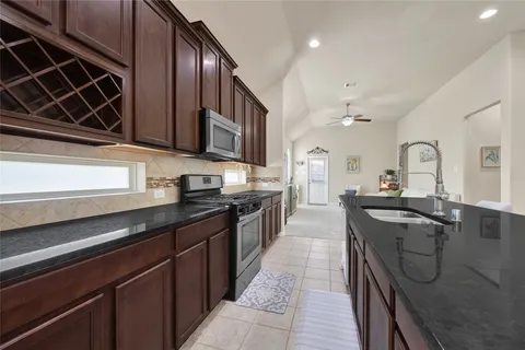 a kitchen with stainless steel appliances granite countertop a sink stove and cabinets