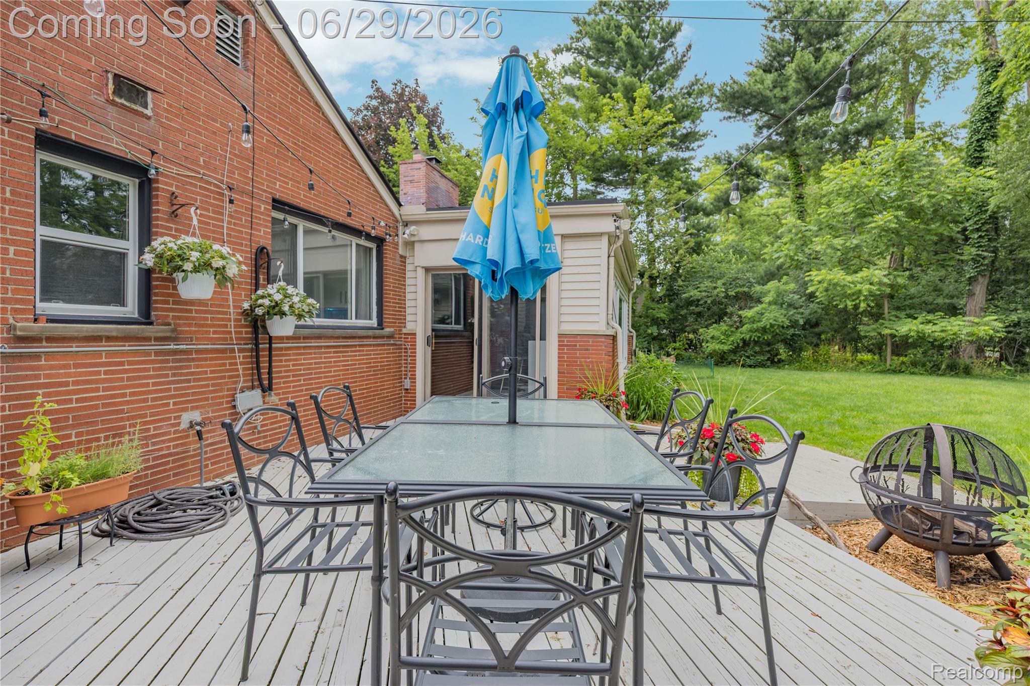 6085 Worlington Road Bloomfield Hills, MI 48301 - Photo 58 of 75 Expansive outdoor deck featuring light-toned wood-finish planks, string lighting, and direct access to a grassy yard surrounded by mature trees