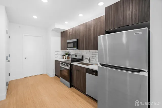 a kitchen with wooden cabinets and stainless steel appliances