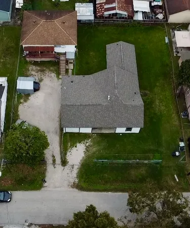 an aerial view of a house with a yard