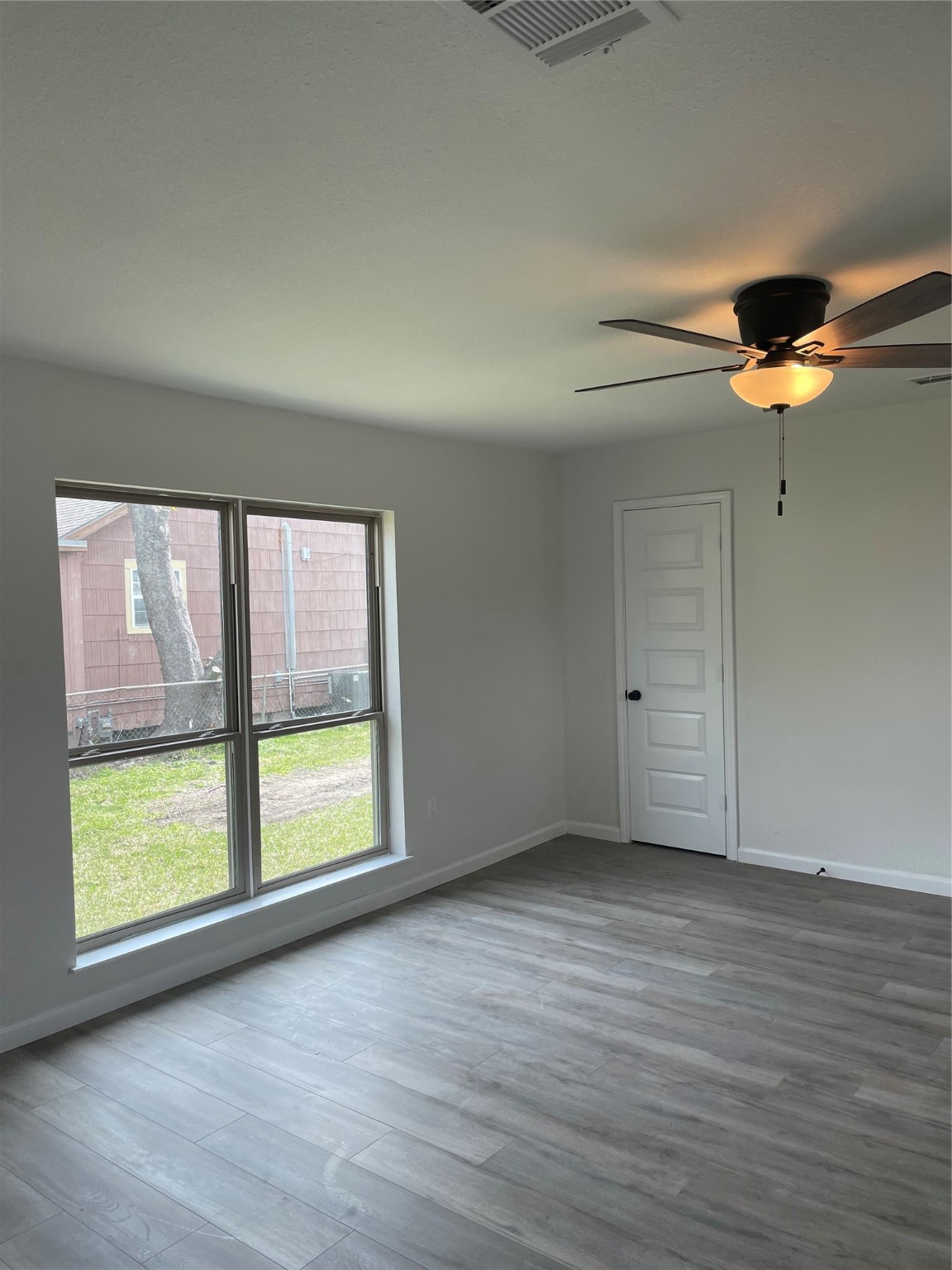 6929 San Angelo Street Houston, TX 77020 - Photo 5 of 24 a view of an empty room with a window and wooden floor