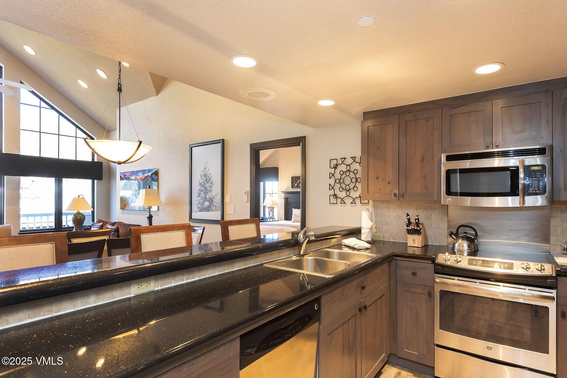 210 Offerson Road, Unit R203 WEEK 14 Beaver Creek, CO 81620 - Photo 8 of 31 a large kitchen with granite countertop a large counter top stainless steel appliances and a large window