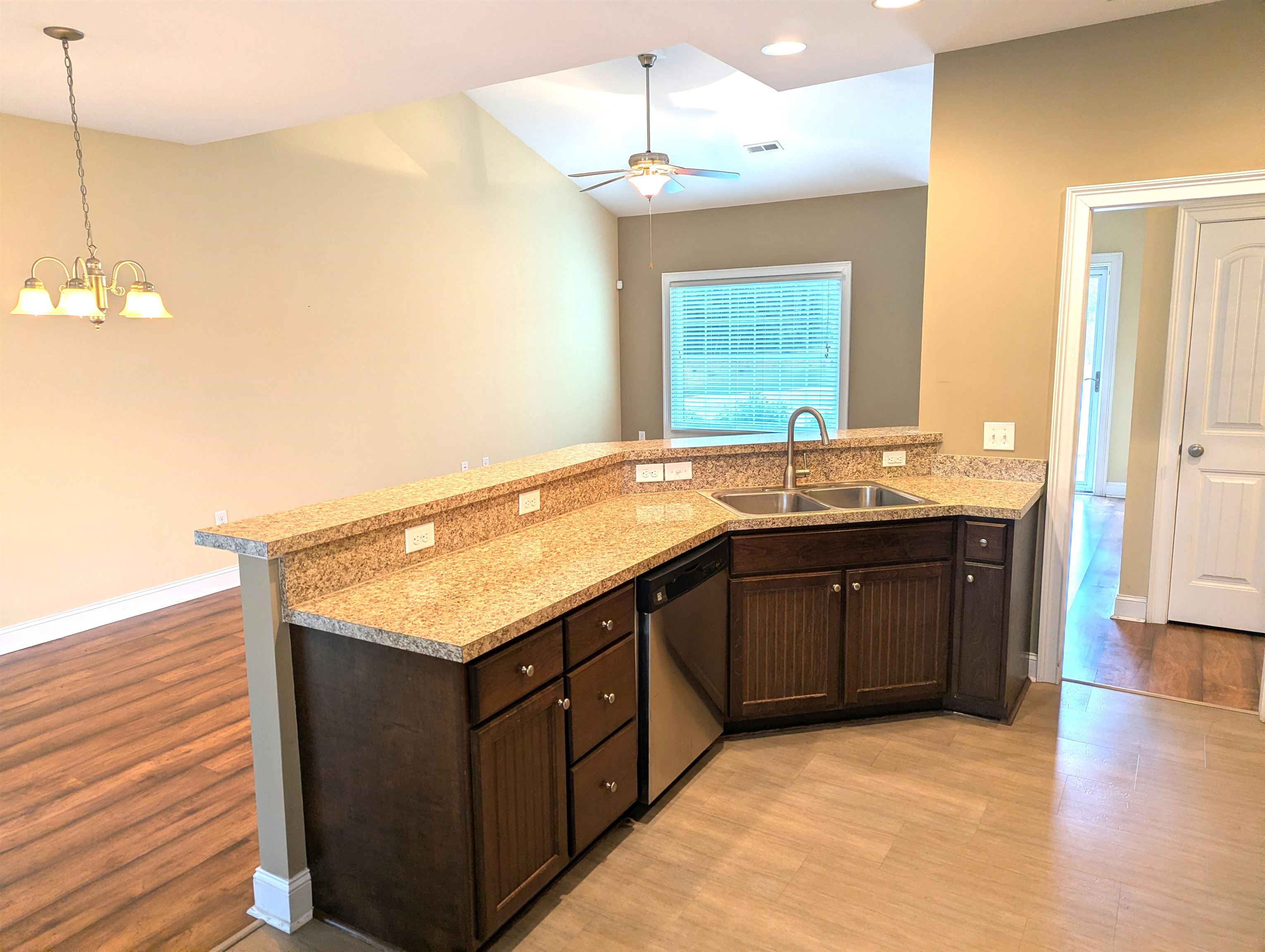 1100 Eureka Trail Longs, SC 29568 - Photo 12 of 40 Kitchen featuring dark brown cabinets, dishwasher, a peninsula, light wood-type flooring, and light stone counters