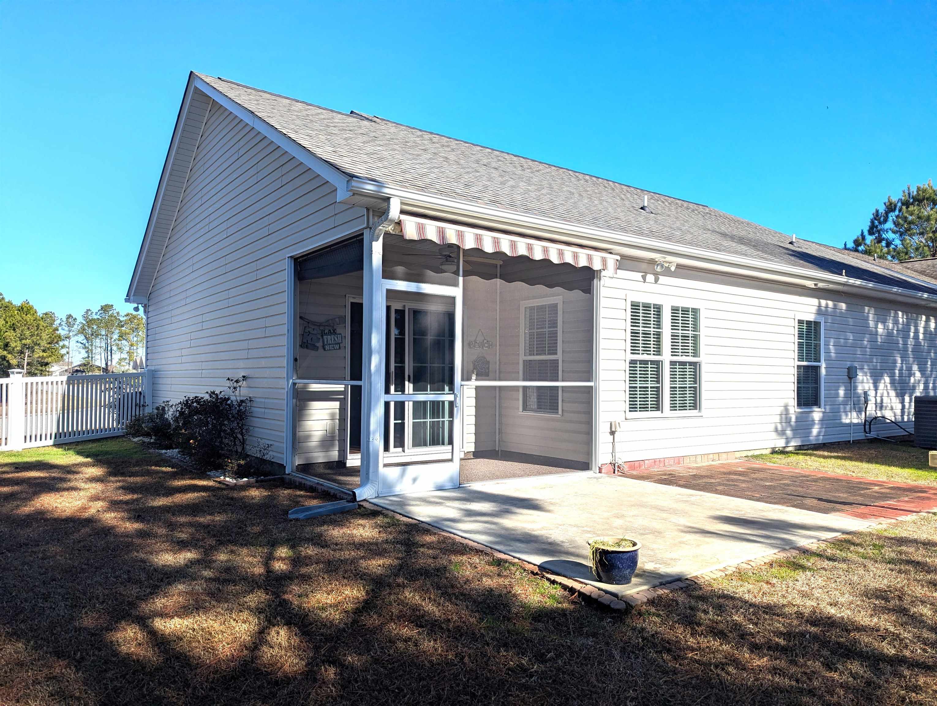 1100 Eureka Trail Longs, SC 29568 - Photo 26 of 40 Back of property featuring a sunroom, roof with shingles, and a patio