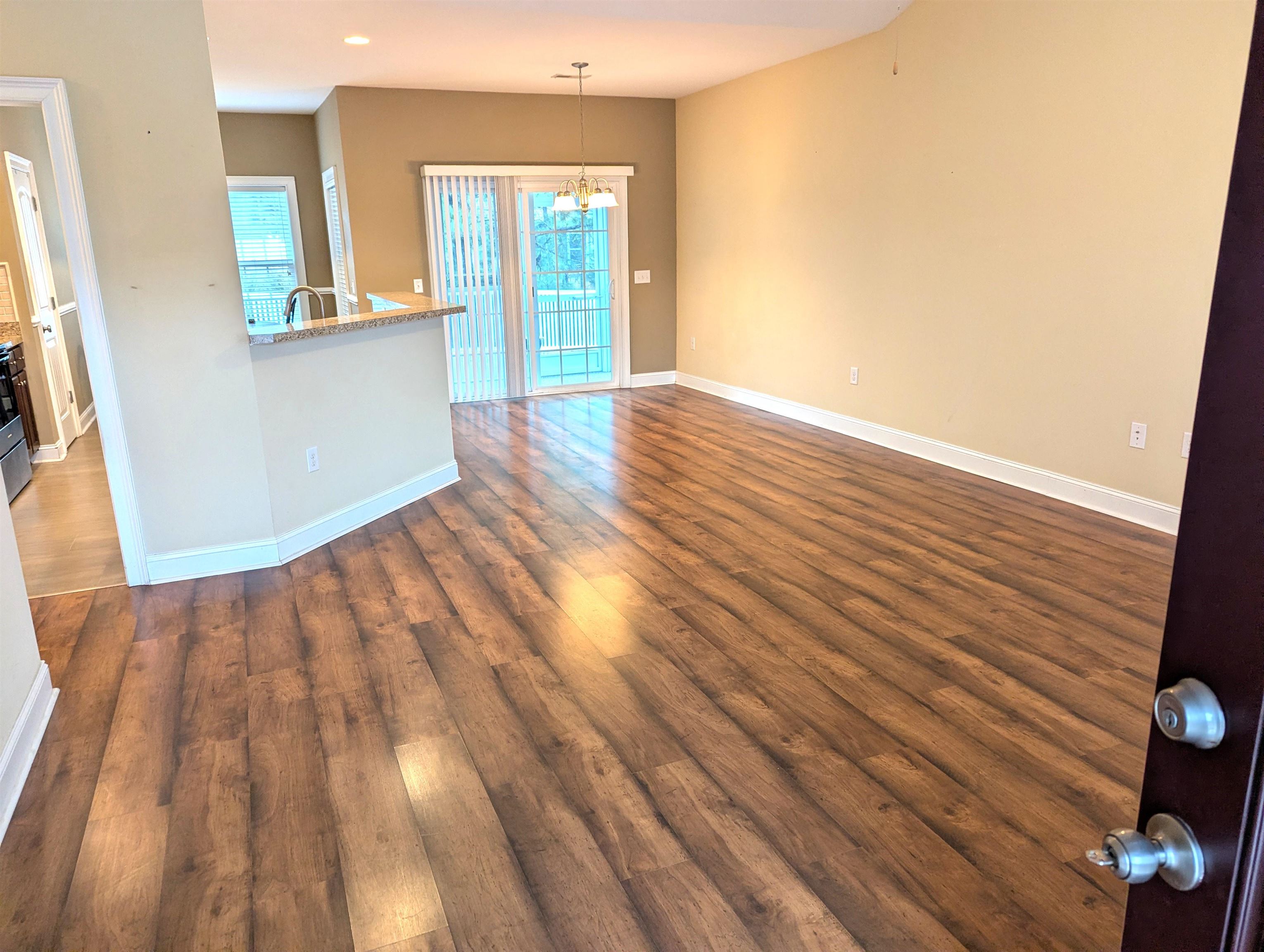 1100 Eureka Trail Longs, SC 29568 - Photo 6 of 40 Unfurnished living room featuring dark wood finished floors and a chandelier