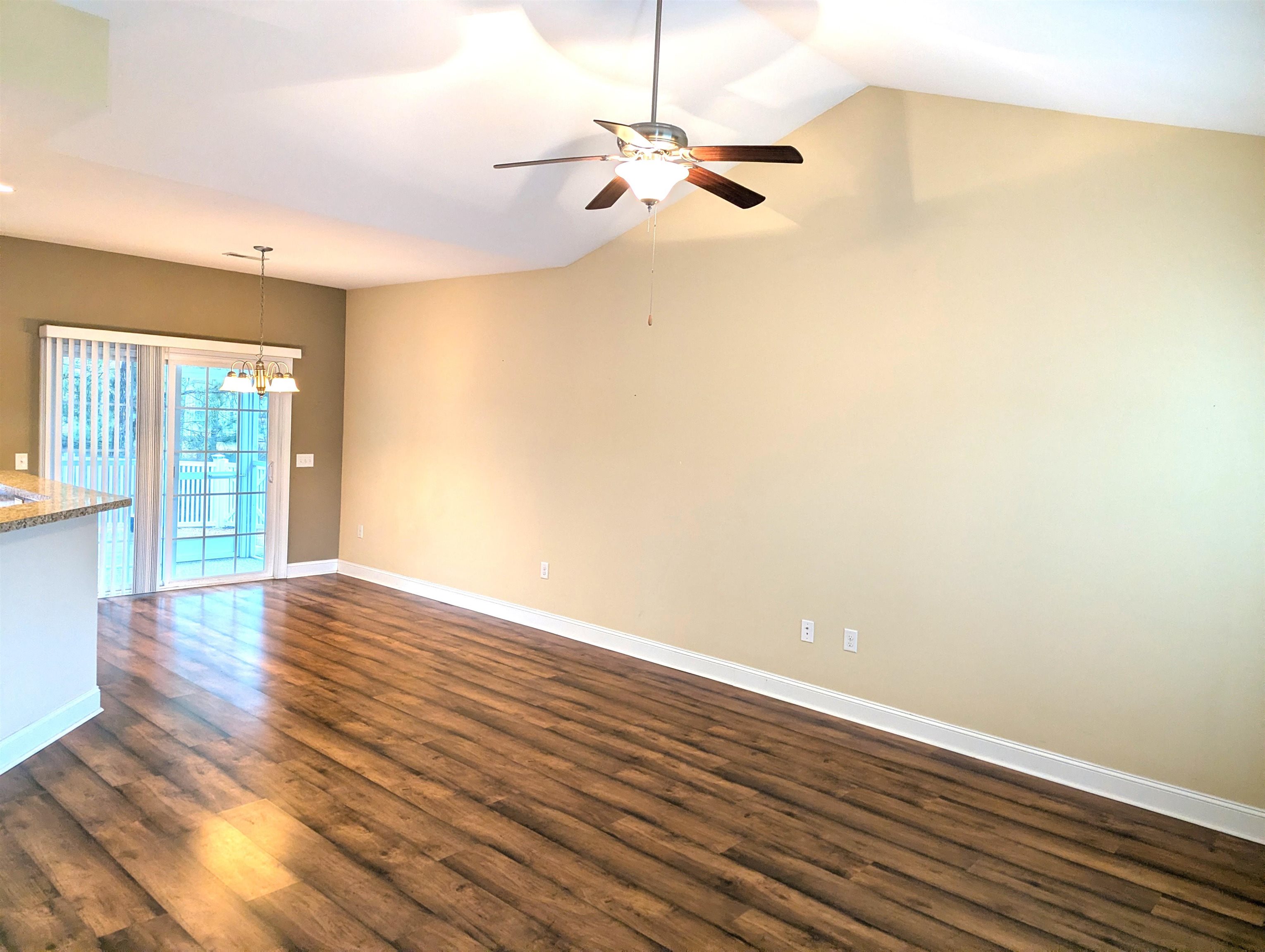 1100 Eureka Trail Longs, SC 29568 - Photo 7 of 40 Unfurnished room featuring a chandelier, vaulted ceiling, dark wood finished floors, and a ceiling fan