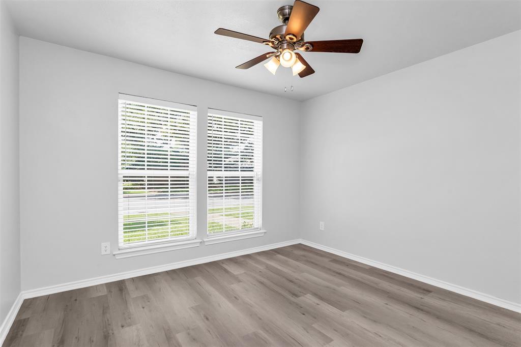 7233 Rustic Valley Drive Dallas, TX 75248 - Photo 15 of 21 an empty room with wooden floor fan and windows