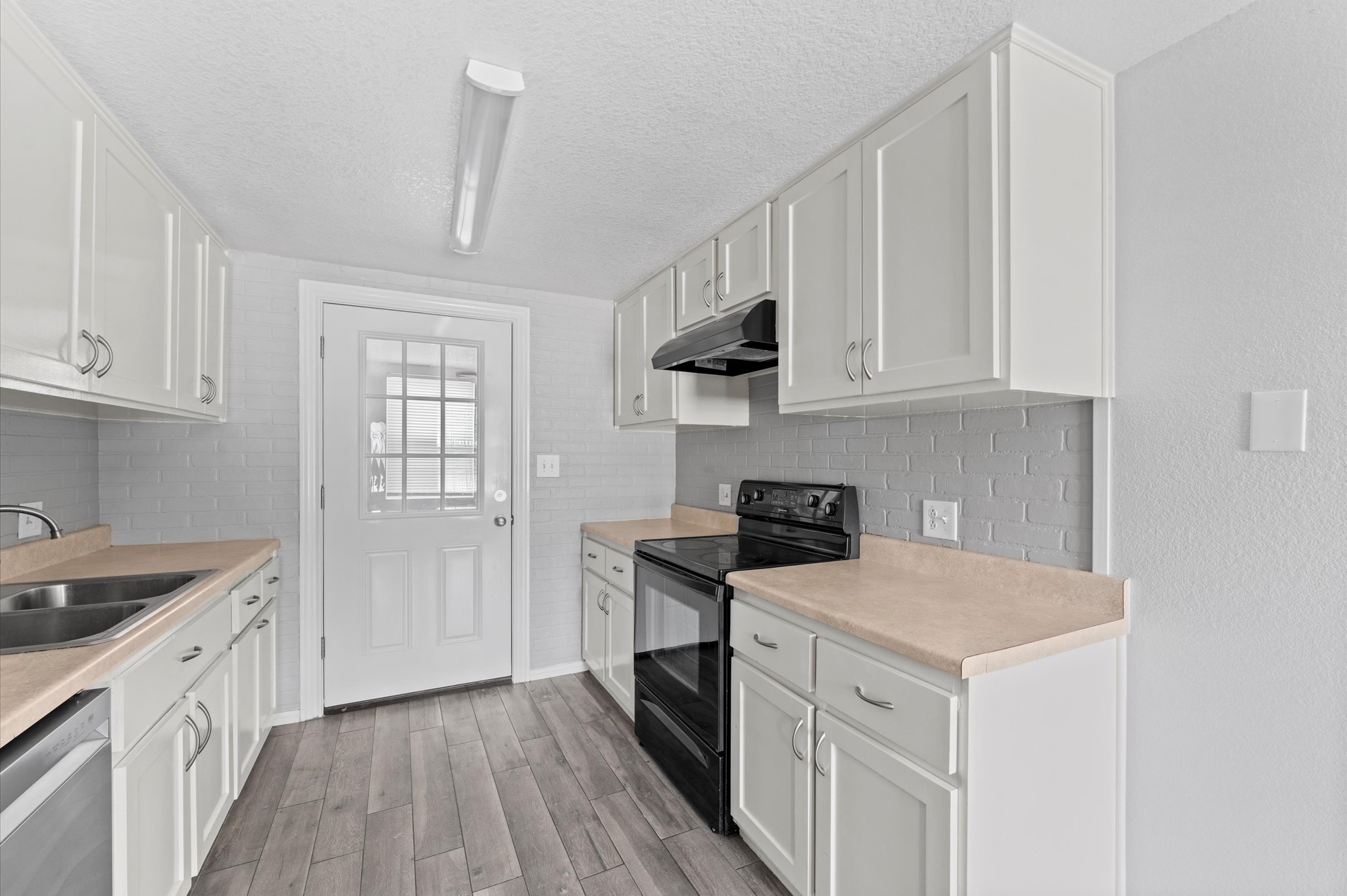2024 Jean Street Houston, TX 77204 - Photo 12 of 23 a kitchen with a white stove top oven and white cabinets