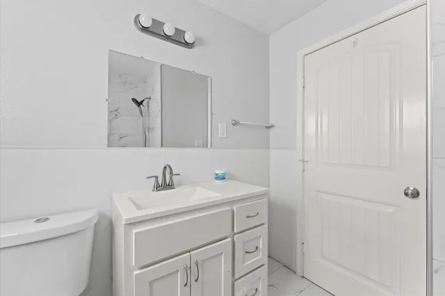 a bathroom with a sink toilet vanity and a tub