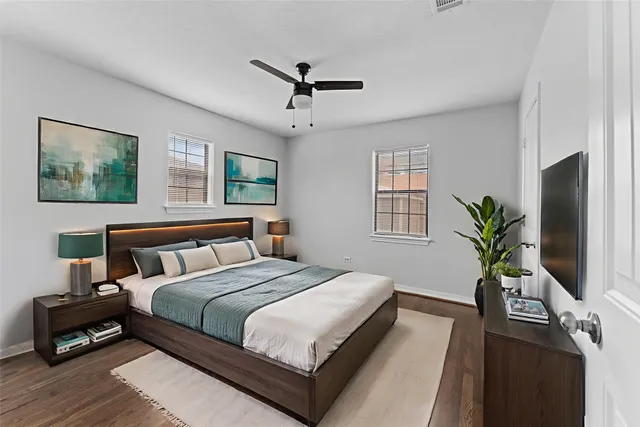 a bedroom with bed a couch and a potted plant