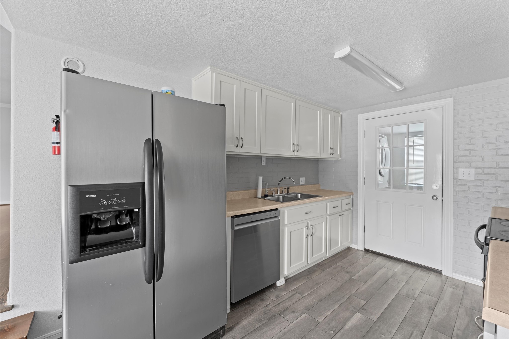 2024 Jean Street Houston, TX 77204 - Photo 4 of 23 a kitchen with stainless steel appliances a refrigerator a sink and white cabinets