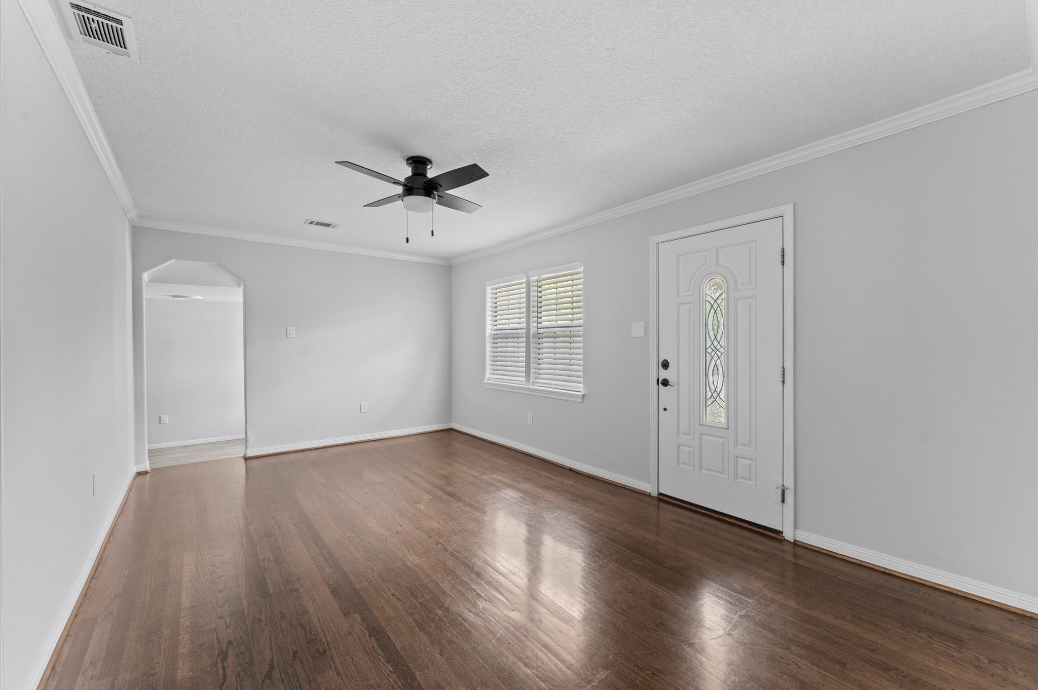 2024 Jean Street Houston, TX 77204 - Photo 9 of 23 a view of an empty room with wooden floor and a ceiling fan