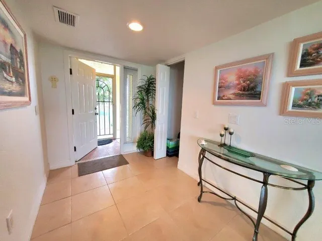 a living room with furniture and potted plant with wooden floor