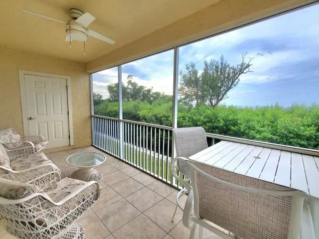 a view of a patio with a table chairs and a floor to ceiling window
