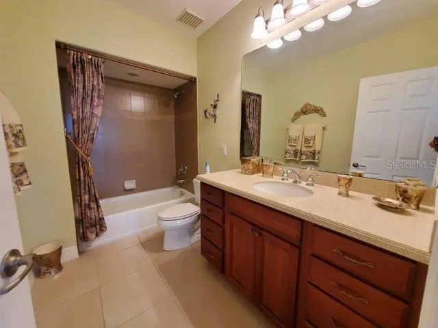 a bathroom with a double vanity sink toilet mirror and shower