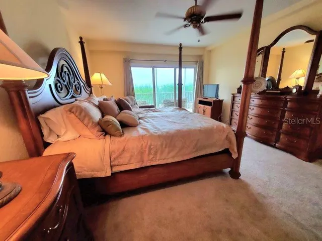 a bedroom with a bed a dresser and windows
