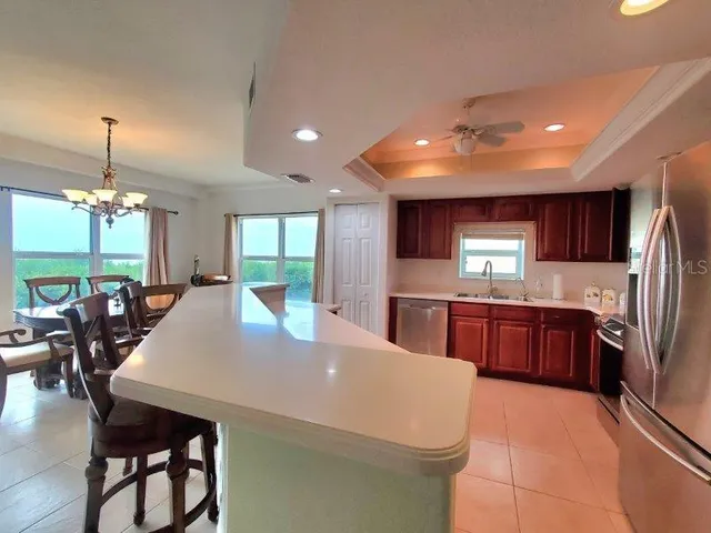 a kitchen with stainless steel appliances kitchen island granite countertop a refrigerator a stove a sink dishwasher with a dining table and chairs