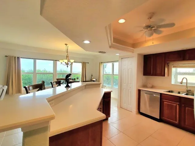 a large kitchen with stainless steel appliances a large counter top a stove a chimney a sink and dishwasher