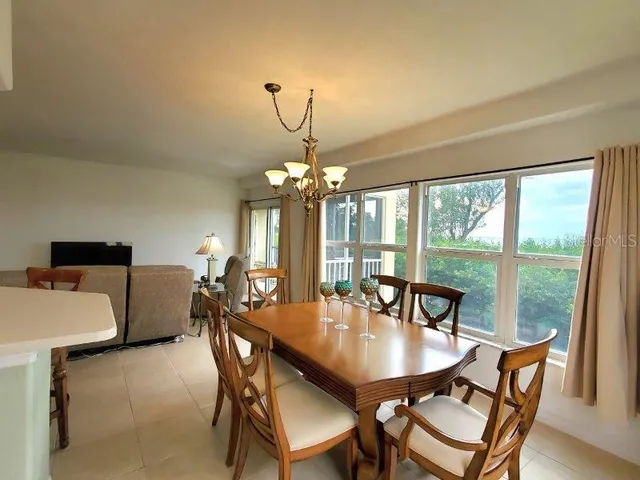 a dining room with furniture a chandelier and window