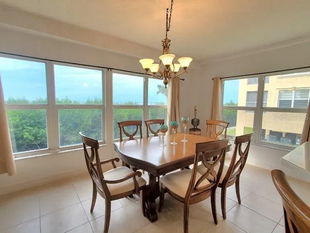 a dining room with furniture a chandelier and a rug