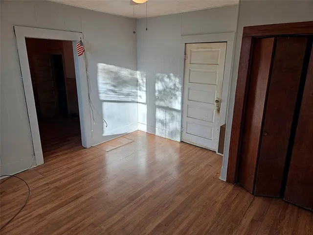 an empty room with wooden floor and entrance