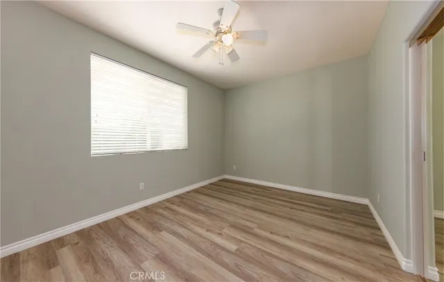 an empty room with a window and a ceiling fan