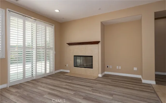 a view of empty room with wooden floor and fireplace