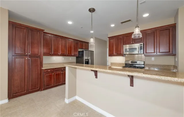 a kitchen with stainless steel appliances granite countertop a sink refrigerator and cabinets