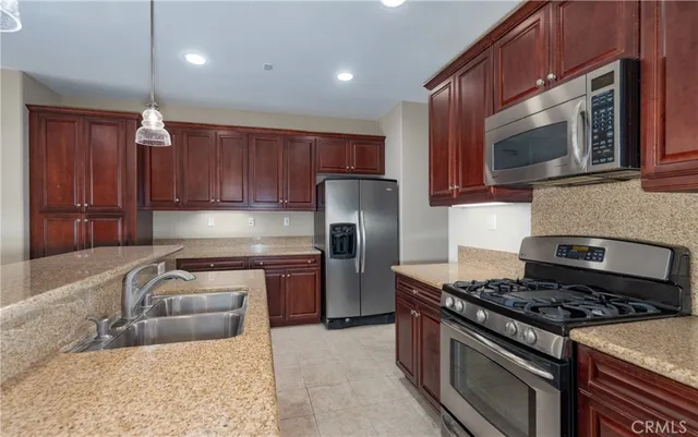 a kitchen with stainless steel appliances granite countertop a stove microwave sink and refrigerator