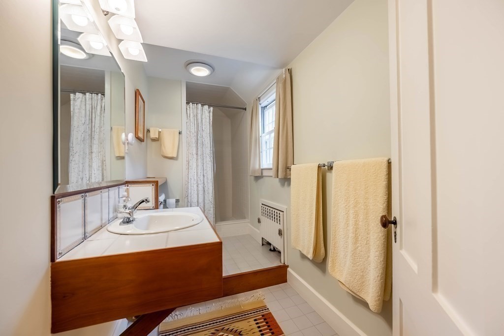 9 A Bancroft Road Andover, MA 01810 - Photo 32 of 37 a bathroom with a sink a mirror and a shower