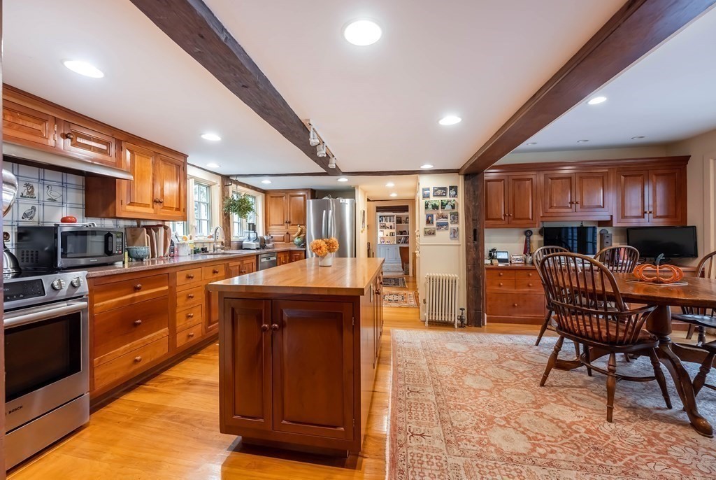 9 A Bancroft Road Andover, MA 01810 - Photo 6 of 37 a kitchen with stainless steel appliances granite countertop a table chairs sink and cabinets