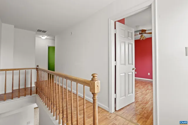 a view of a hallway with wooden floor and staircase