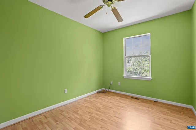 a view of a room with a large window and ceiling fan