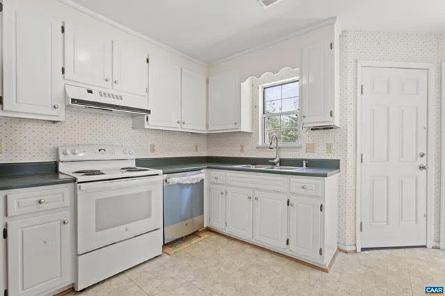 a kitchen with granite countertop white cabinets and white appliances