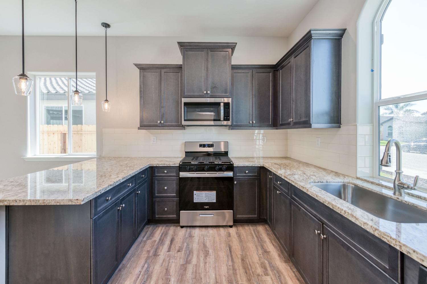 778 Shasta Street Madera, CA 93638 - Photo 7 of 28 a kitchen with stainless steel appliances granite countertop a sink stove and refrigerator
