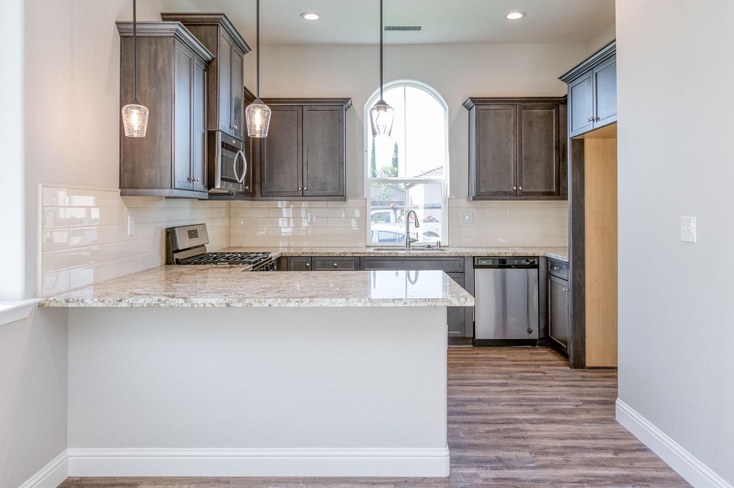 778 Shasta Street Madera, CA 93638 - Photo 10 of 28 a view of a kitchen with a sink a counter top space and stainless steel appliances