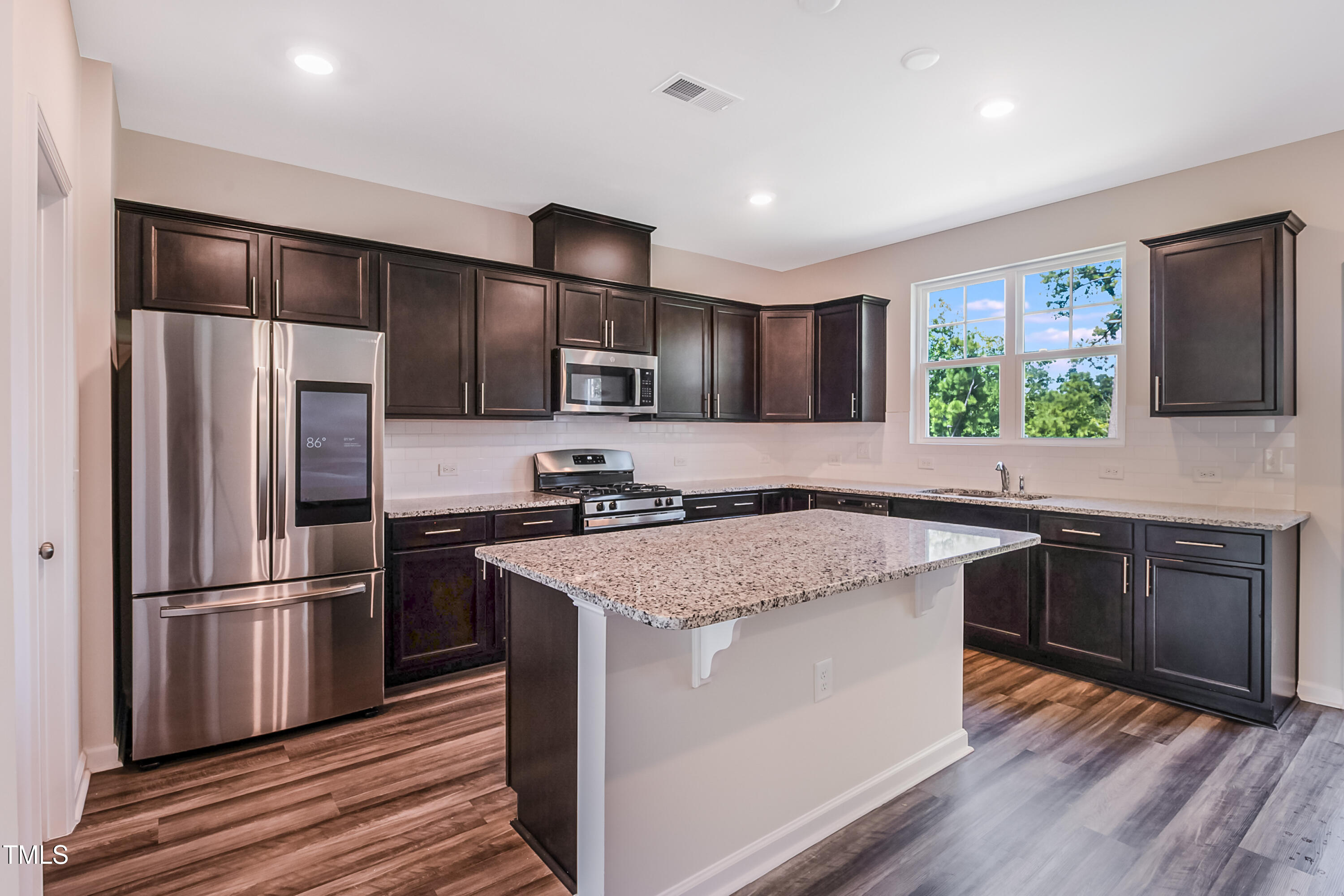 1032 Shoreside Drive Durham, NC 27713 - Photo 3 of 31 a kitchen with stainless steel appliances granite countertop a refrigerator a sink dishwasher a stove and white cabinets with wooden floor