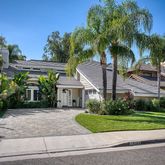 a front view of a house with a yard and potted plants
