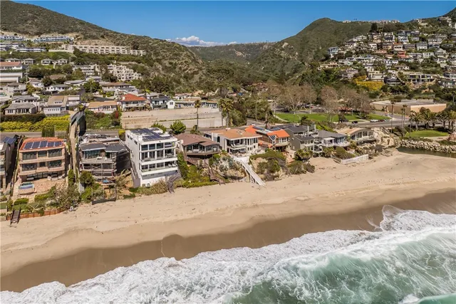 a front view of multiple houses with palm trees