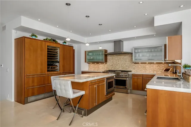 a view of a dining room and livingroom with furniture wooden floor a rug a flat screen tv a rug and a chandelier