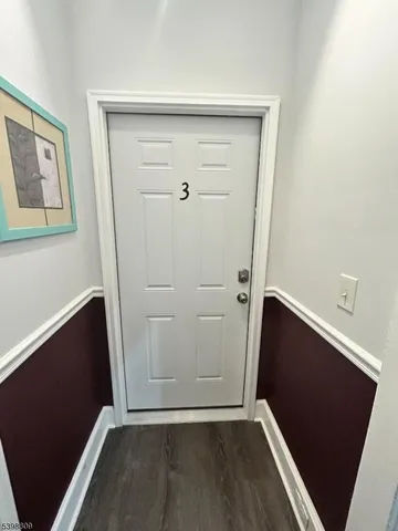 an empty room with wooden floor and staircase