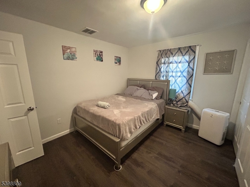142 Mapes Avenue, Unit 3 Newark, NJ 07112 - Photo 5 of 8 a bed sitting in a bedroom next to a lamp