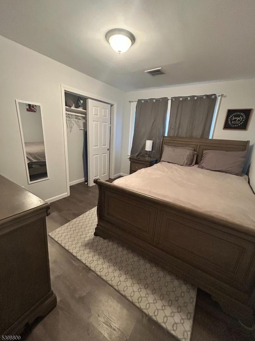 142 Mapes Avenue, Unit 3 Newark, NJ 07112 - Photo 6 of 8 a bedroom with a large bed and wooden floor