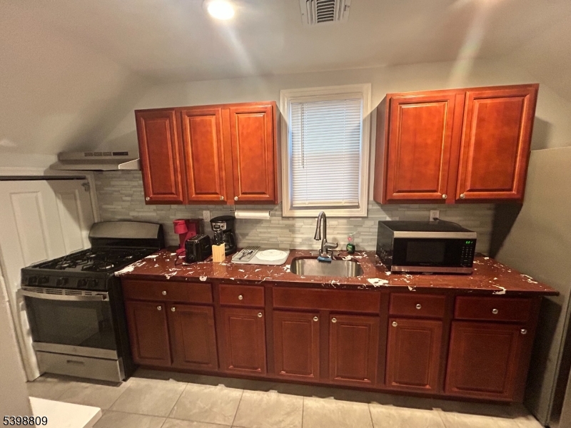 142 Mapes Avenue, Unit 3 Newark, NJ 07112 - Photo 8 of 8 a kitchen with granite countertop a sink stove and microwave