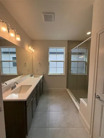 a bathroom with a sink shower and a mirror